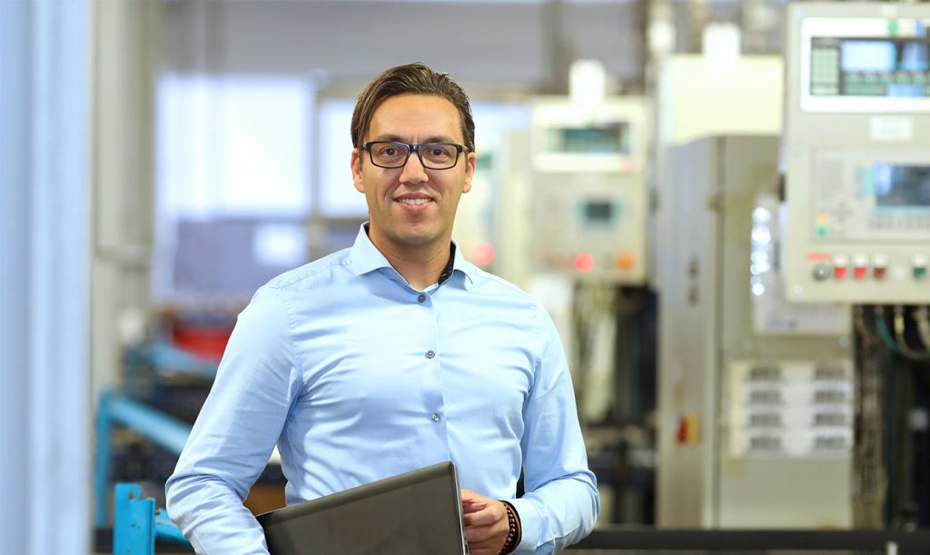 First service employee looks at the camera with laptop in hand